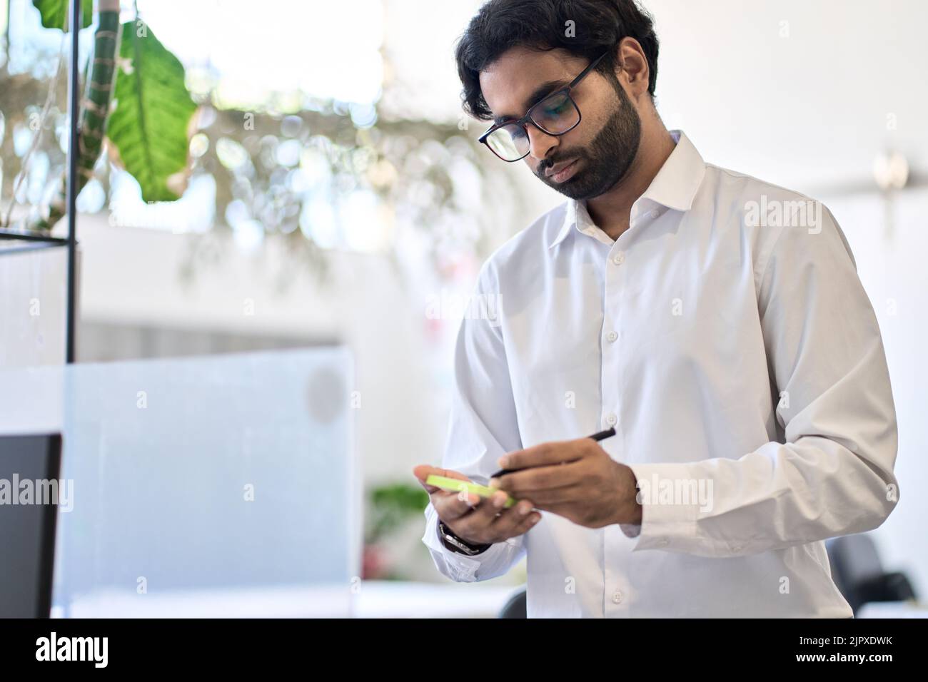 Busy indian professional man executive working in office planning project. Stock Photo