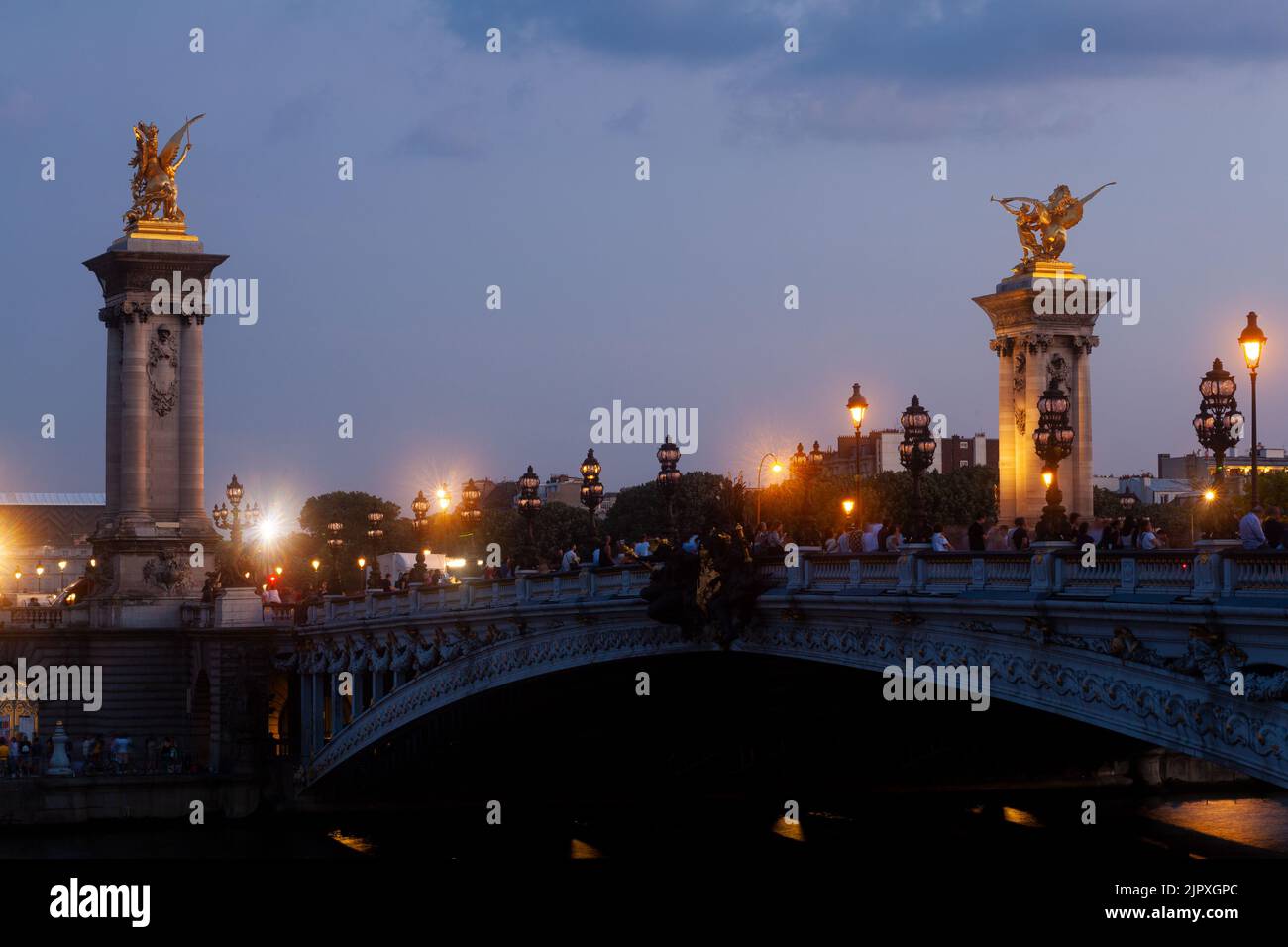 Pont Alexandre III Bridge and illuminated lamp posts at sunset. 7th Arrondissement, Paris, France Stock Photo