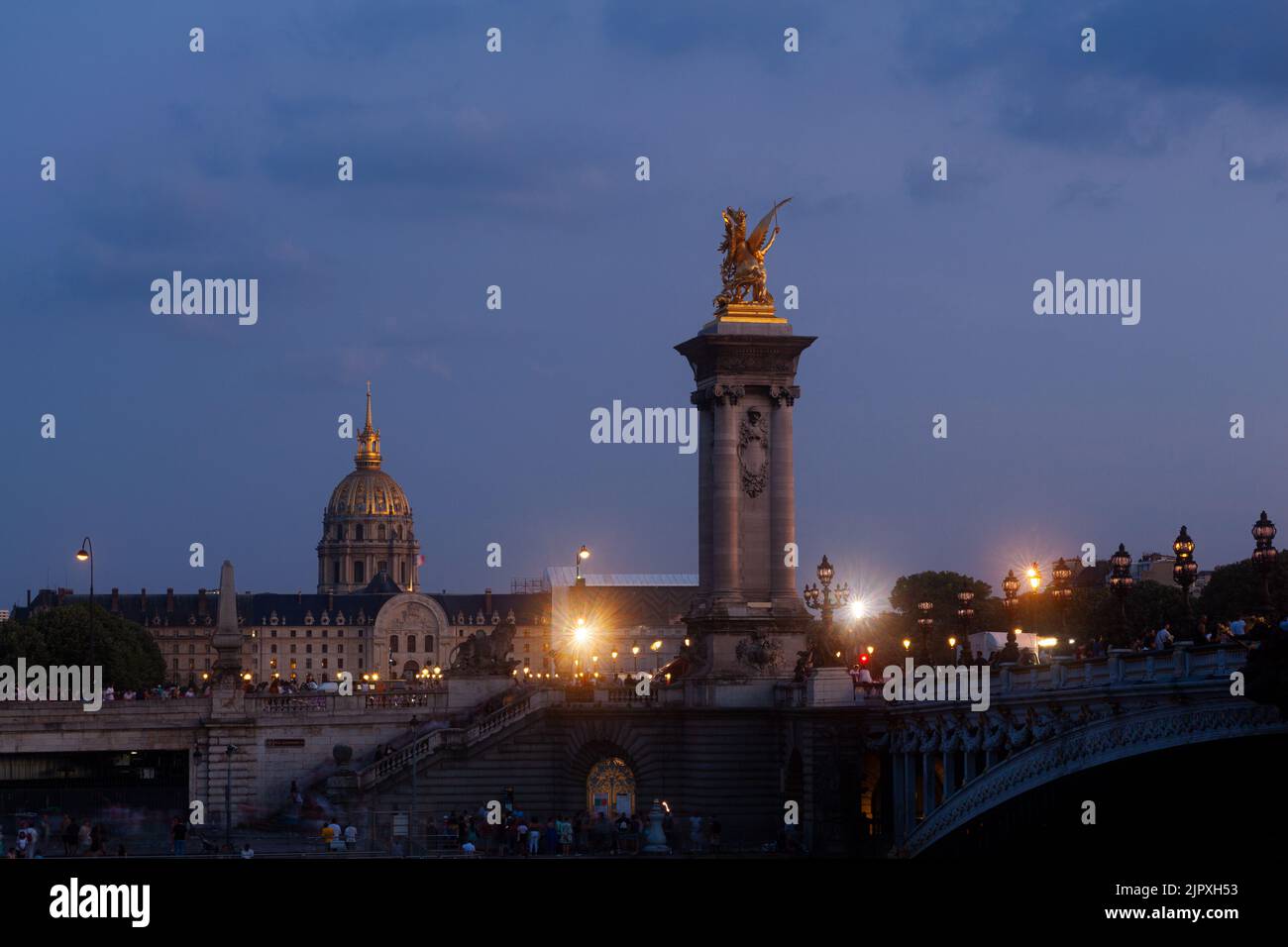 Pont Alexandre III Bridge and illuminated lamp posts at sunset with view of the Invalides. 7th Arrondissement, Paris, France Stock Photo