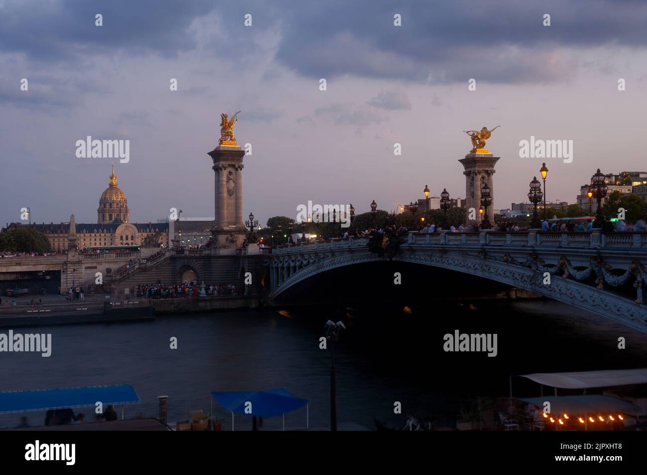 Pont Alexandre III Bridge and illuminated lamp posts at sunset with view of the Invalides. 7th Arrondissement, Paris, France Stock Photo