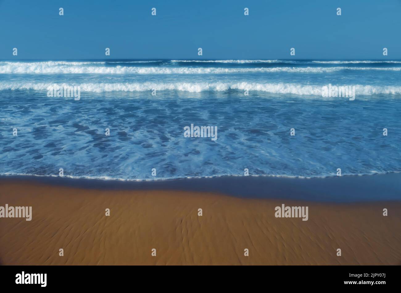 Incoming whitewater waves lapping onto sandy shore Stock Photo
