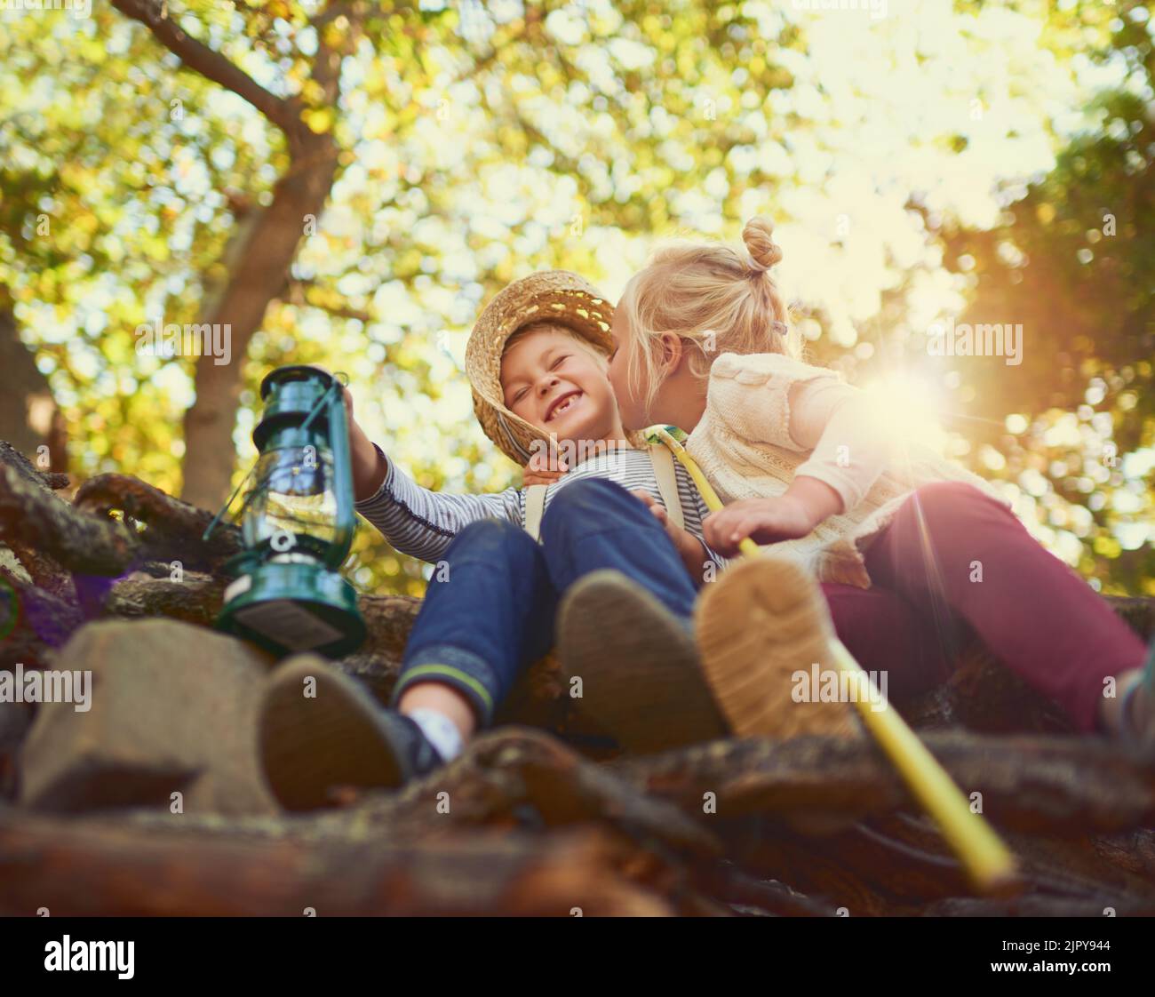 Sharing some sibling love. two little children playing together outdoors. Stock Photo