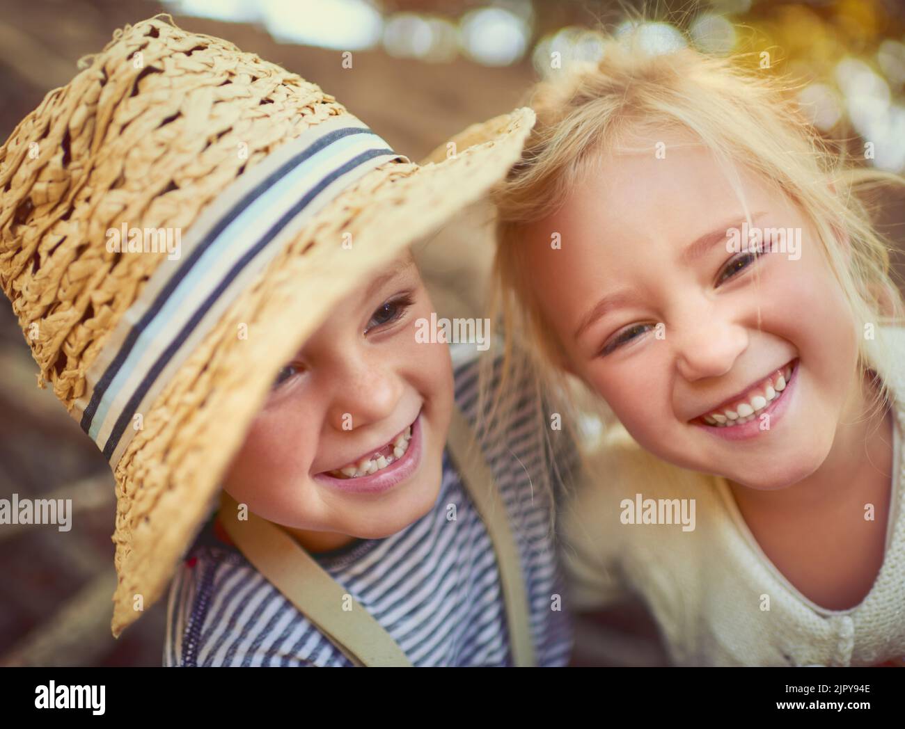 Cute and carefree as can be. Portrait of two little children playing together outdoors. Stock Photo