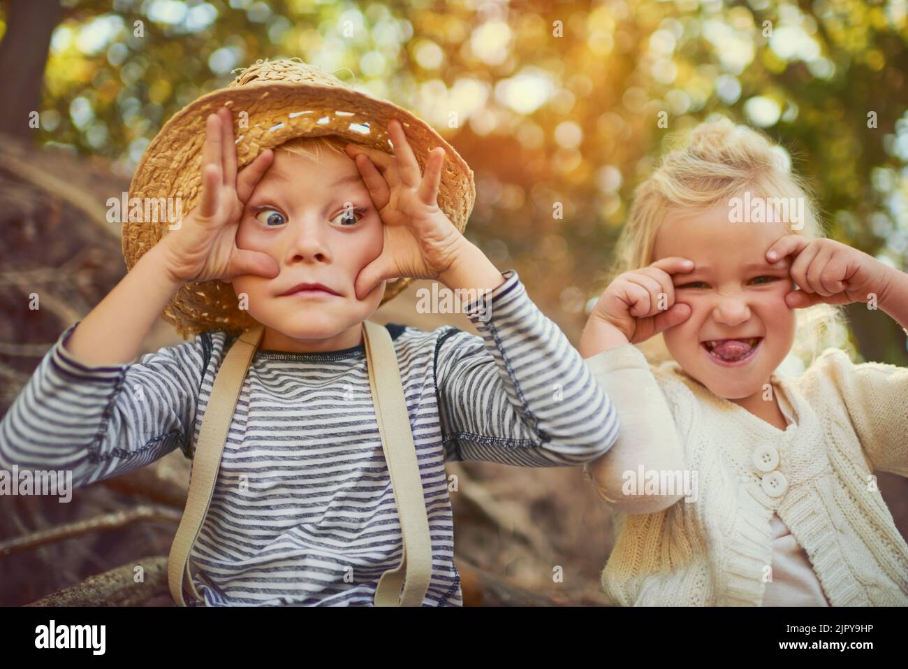 Showing off their funny character. Portrait of two little children playing together outdoors. Stock Photo