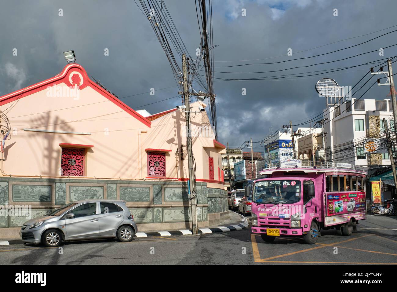 A city bus locally called Potong passes in front of Put Cho (Pud Jor) Temple in Phuket Town (Phuket City), Phuket, Thailand Stock Photo
