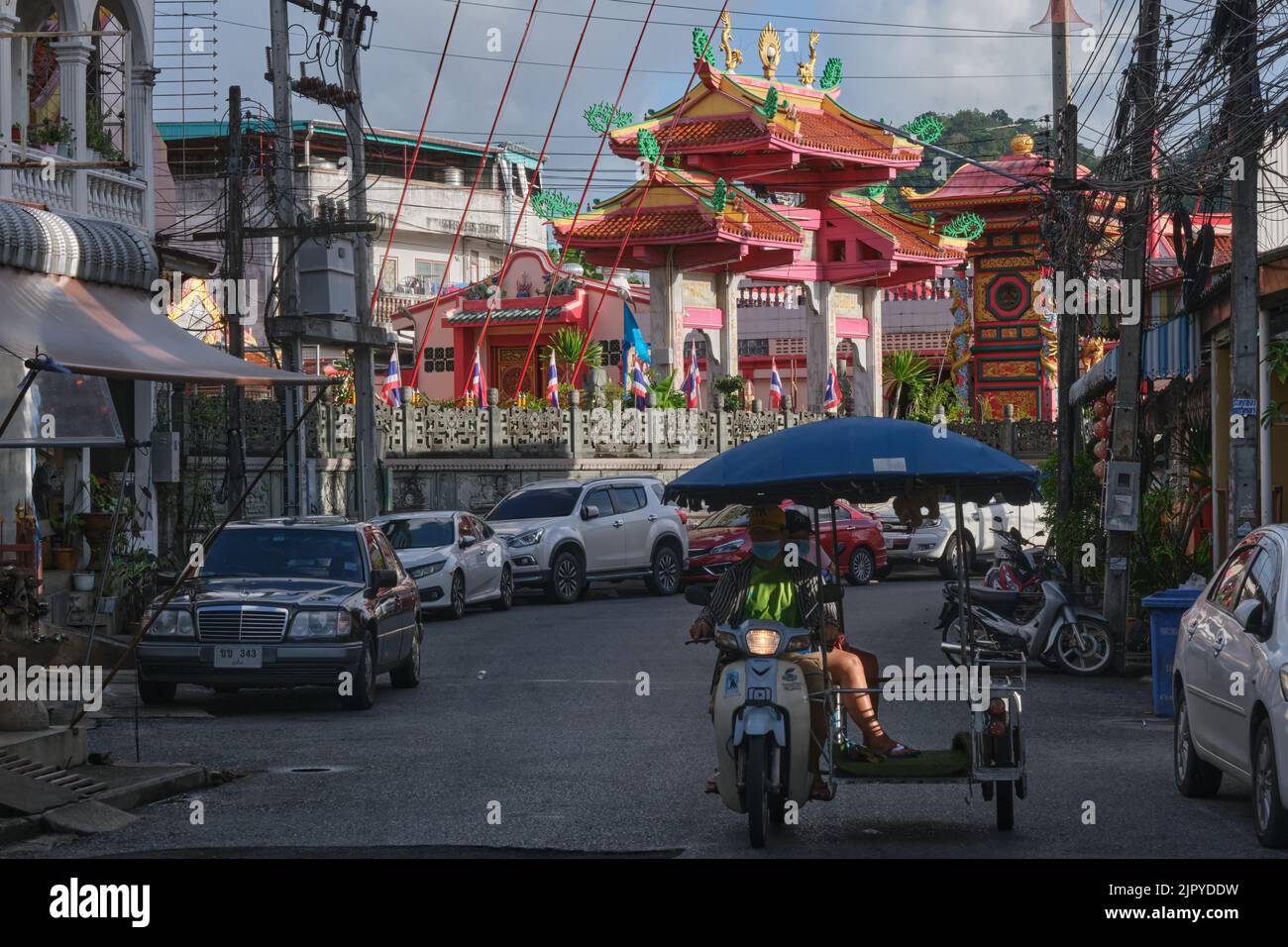 Street scene outside the landmark (Taoist) Jui Tui Temple in Phuket Town (Phuket City), Phuket Thailand, a motorcycle with sidecar passing by Stock Photo