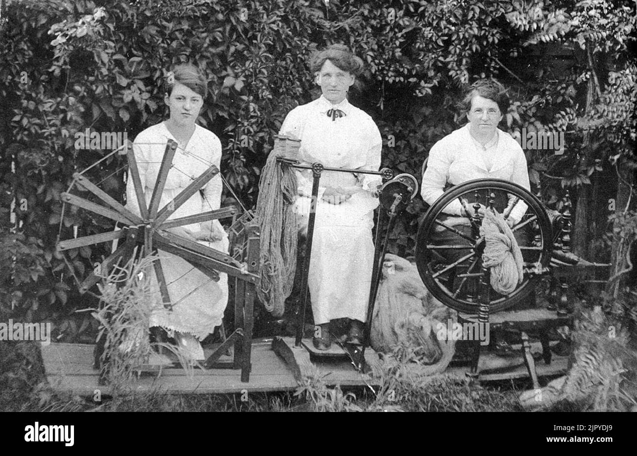 Three women spinning wool to knit socks for soldiers during World War I - Tenterfield, NSW, ca. 1915 Stock Photo