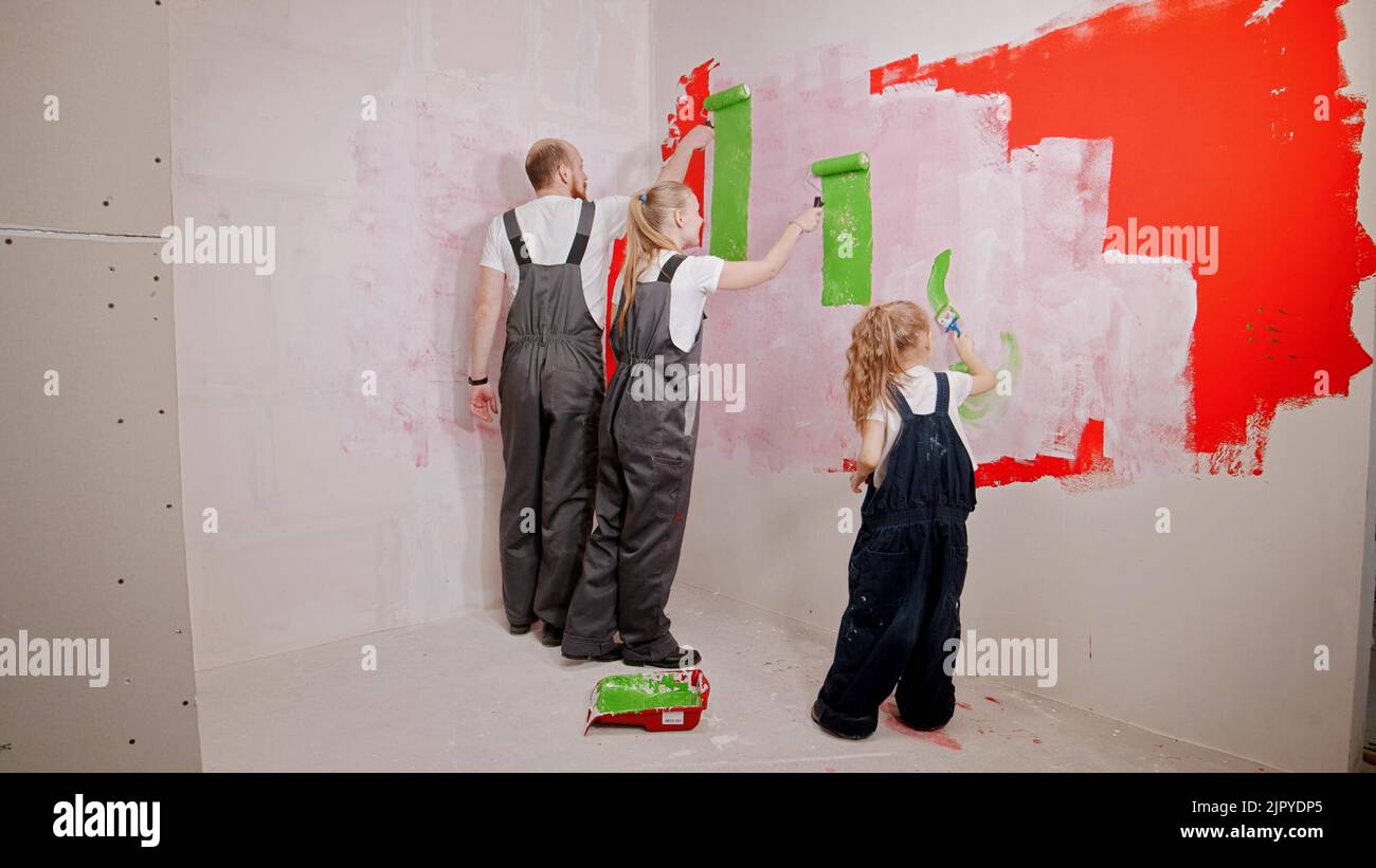 Family painting walls in the new apartment in green color Stock Photo