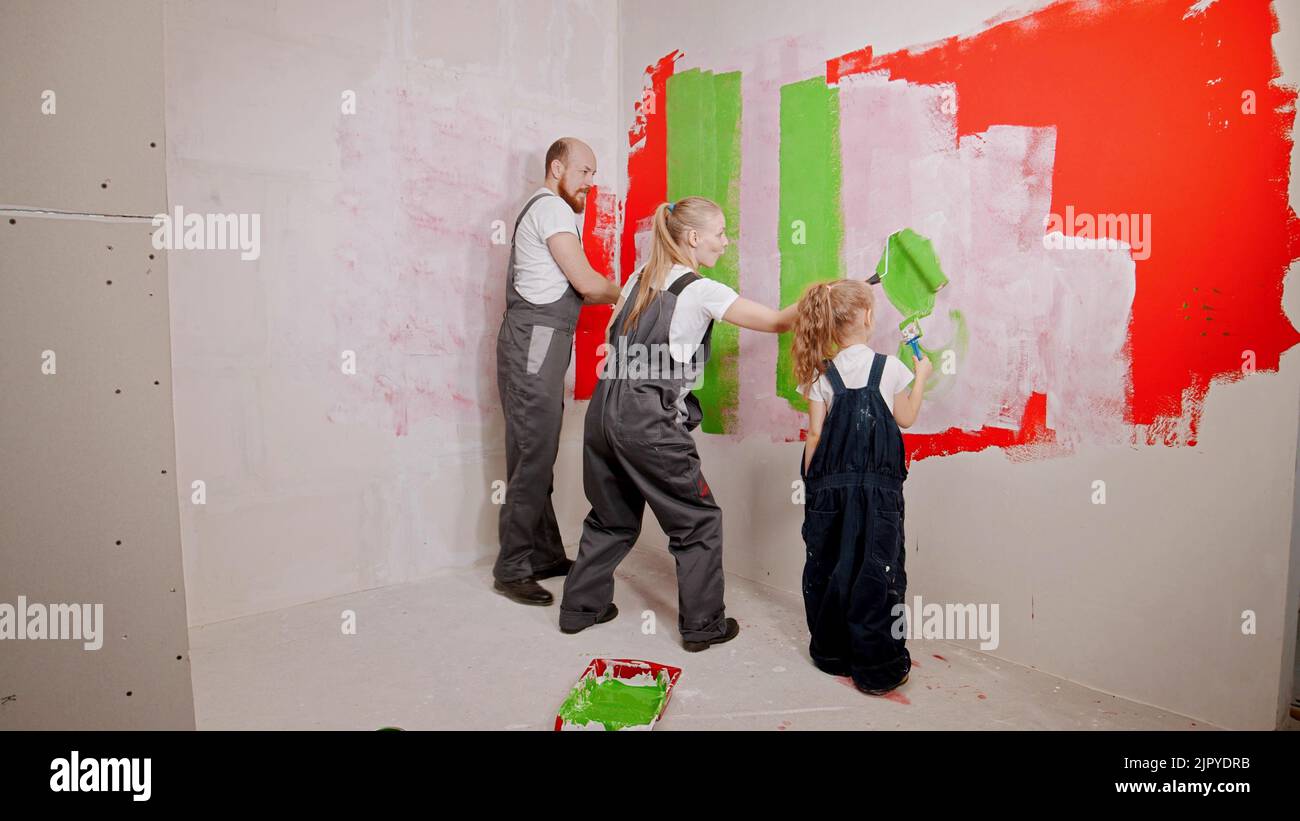 Family painting walls in the new apartment in green and red colors Stock Photo
