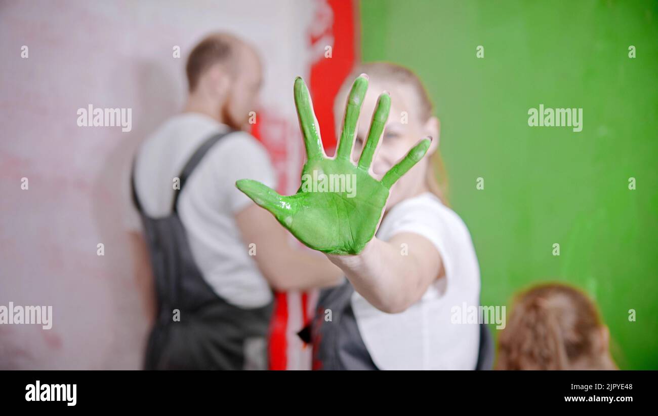 Family painting walls - A woman's palm covered with a green color paint Stock Photo