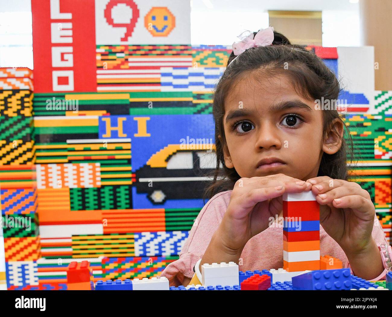 Mumbai, India. 20th Aug, 2022. A girl looks at the camera while using Lego blocks at R City mall