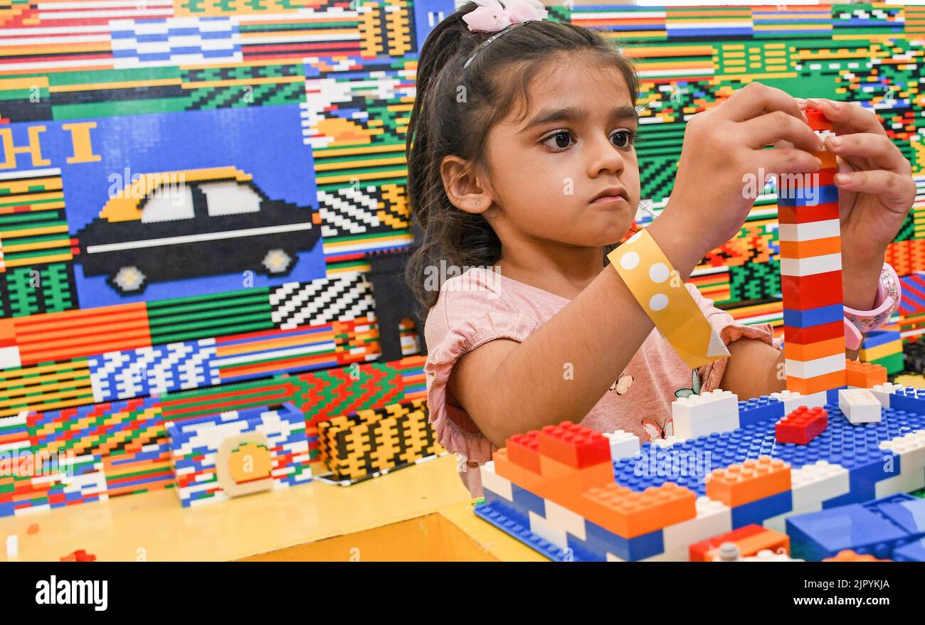 Mumbai, India. 20th Aug, 2022. A girl builds a tower using Lego blocks