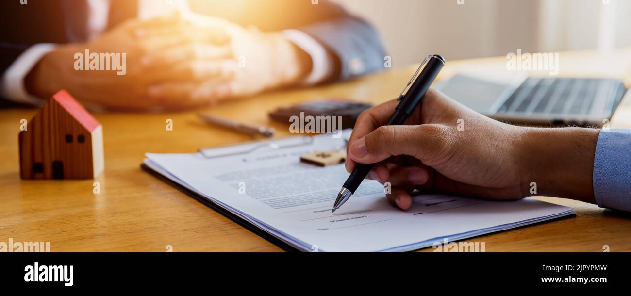 Home buyer signing on contract paper after successful selling and introduce by bank agency , agreement signature on house purchase offer Stock Photo