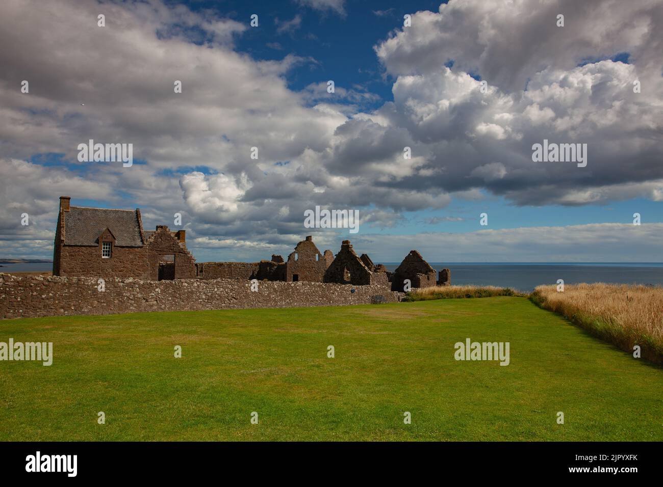 Dunnottar Castle is a ruined medieval fortress located upon a rocky headland on the north-eastern coast of Scotland, about 2 miles south of Stonehaven Stock Photo