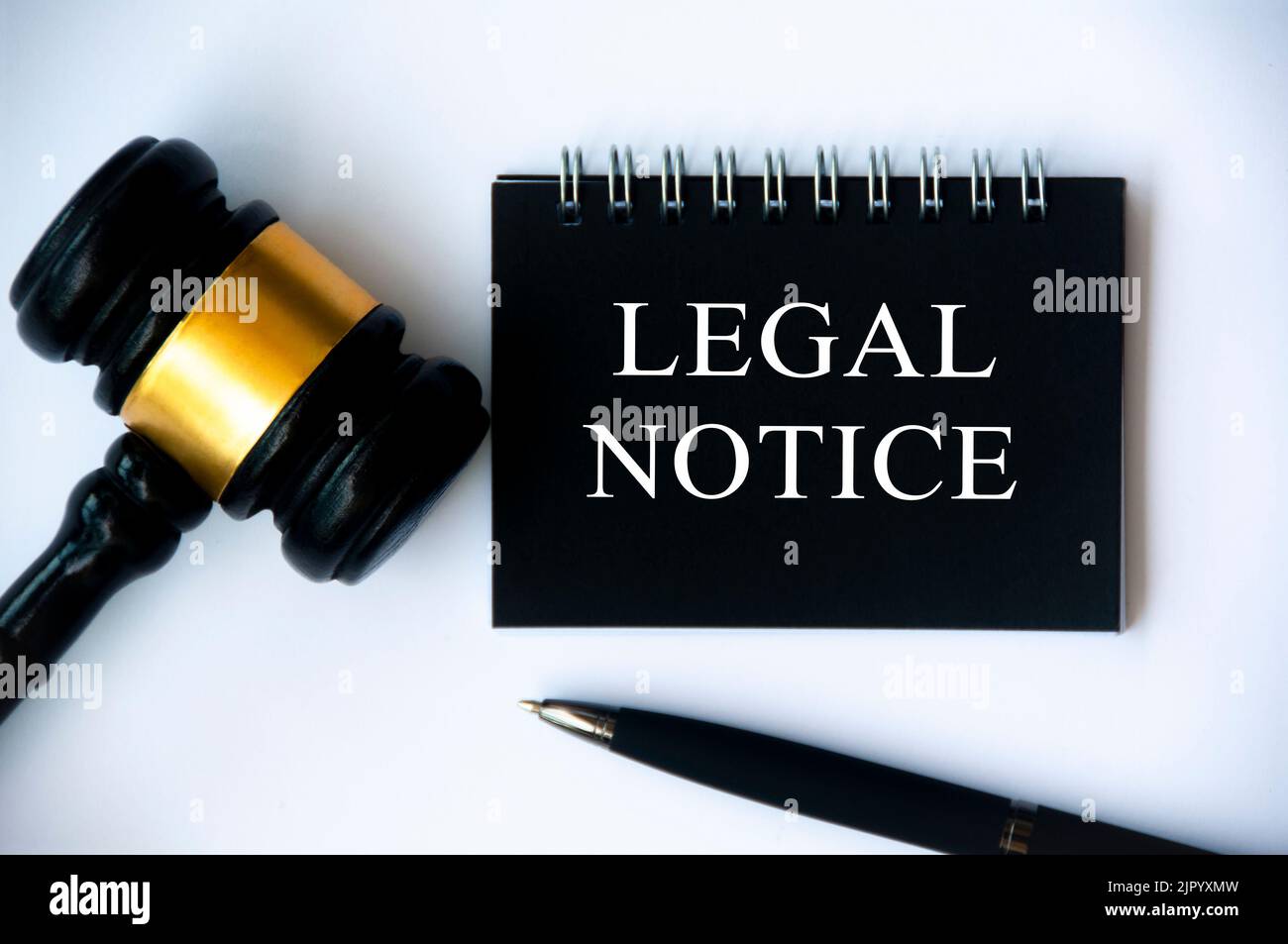 Legal notice text on black notepad with gavel and pen on white background. Legal and law concept. Stock Photo