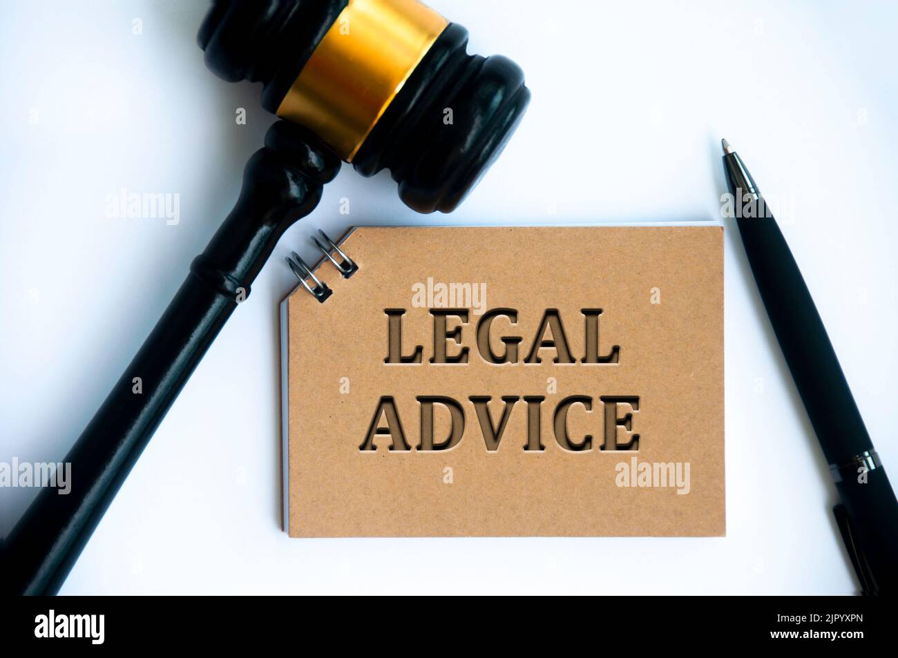 Legal advice text on brown notepad with gavel and pen on white background. Legal and law concept. Stock Photo