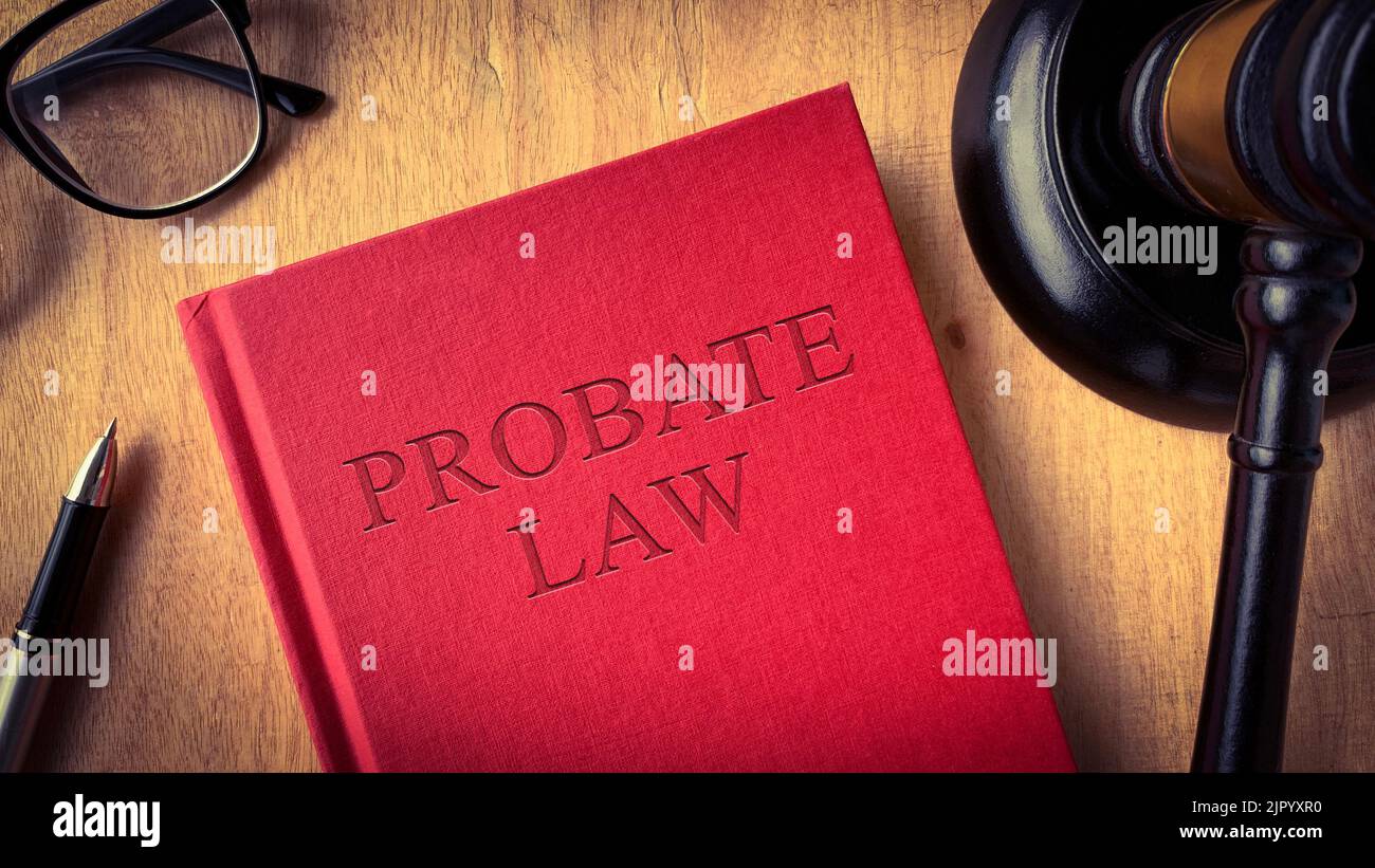 Probate law book on wooden table surrounded with gavel, glasses and pen. Law concept. Stock Photo