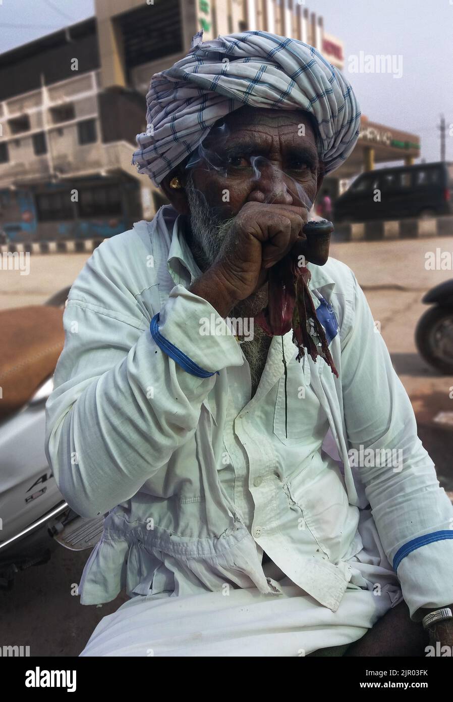 old Rajasthan man wearing traditional dress and smoking chillum Stock Photo