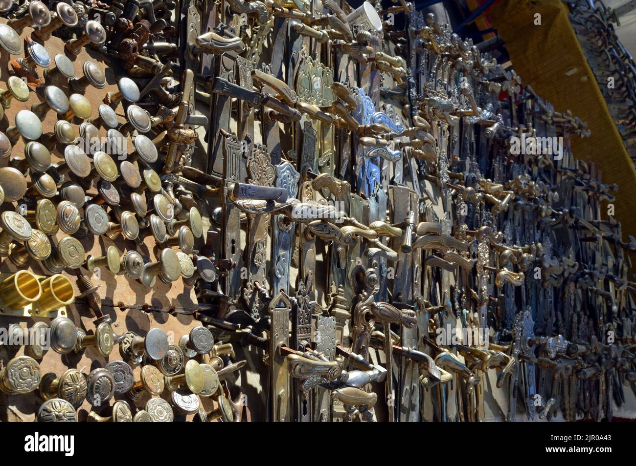 A collection of antique brass door handles and knobs with various