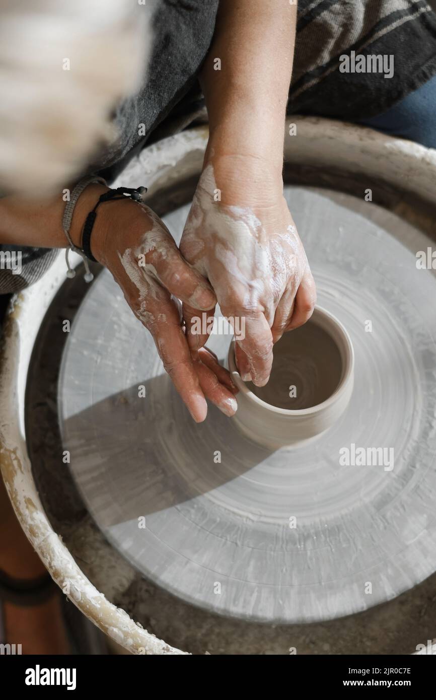 Hands closeup at pottery learning to make clay bowl. People