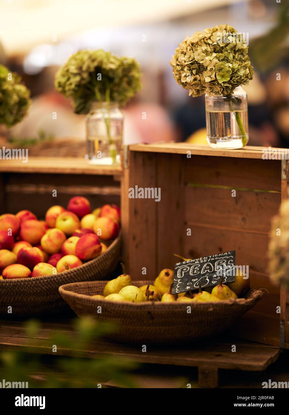 A vertical shot of fresh pears in a wicker basket in a food market in