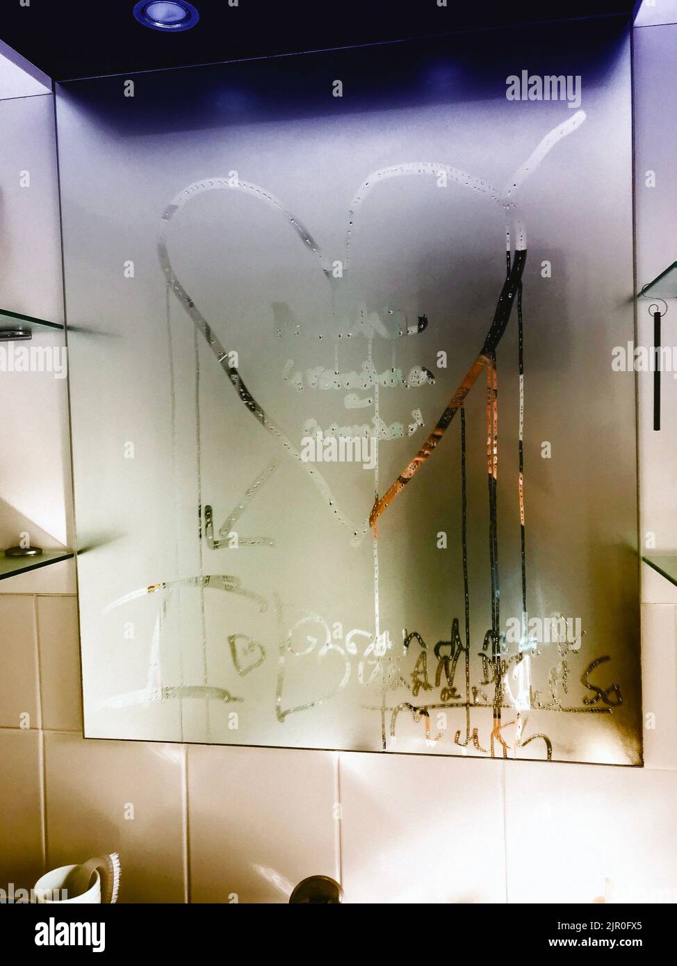 writing in steam on bathroom mirror text and heart symbol Stock Photo