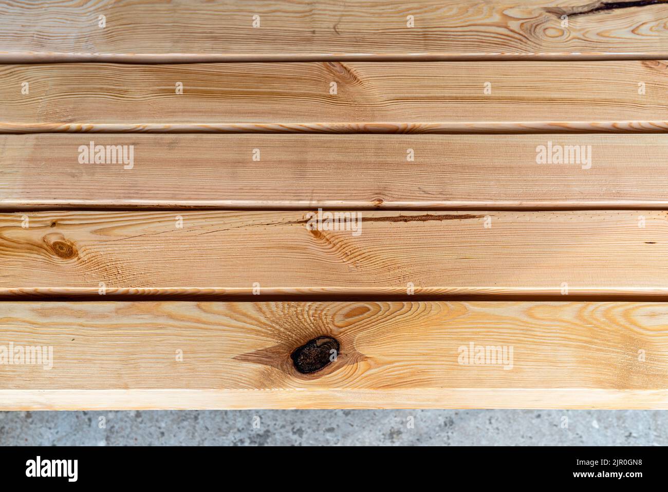 Raw planed pine wooden beams, dimensions 100x100mm, lying next to each other. Stock Photo