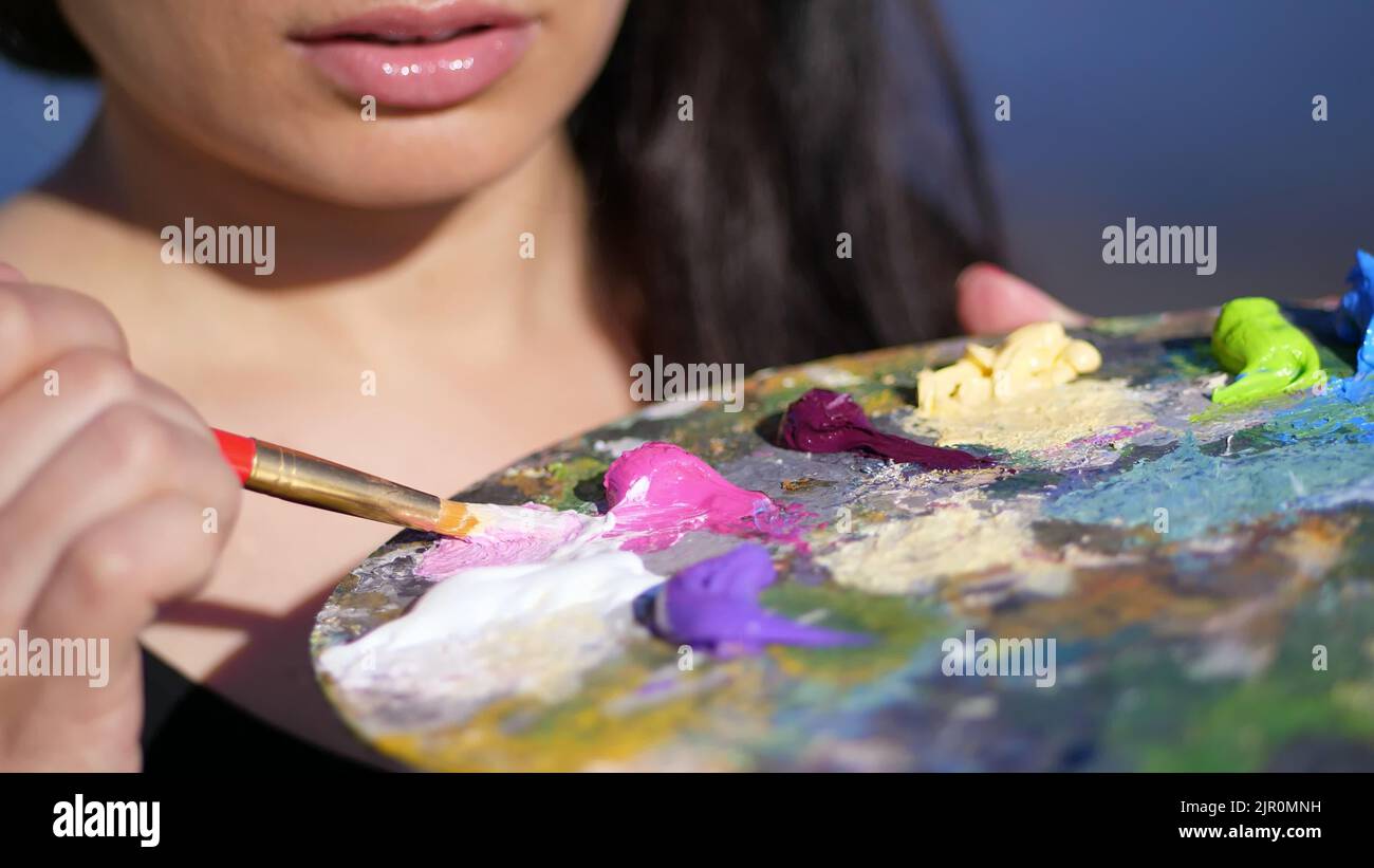 summer,outdoors, close-up of a palette with paints, the woman artist ...