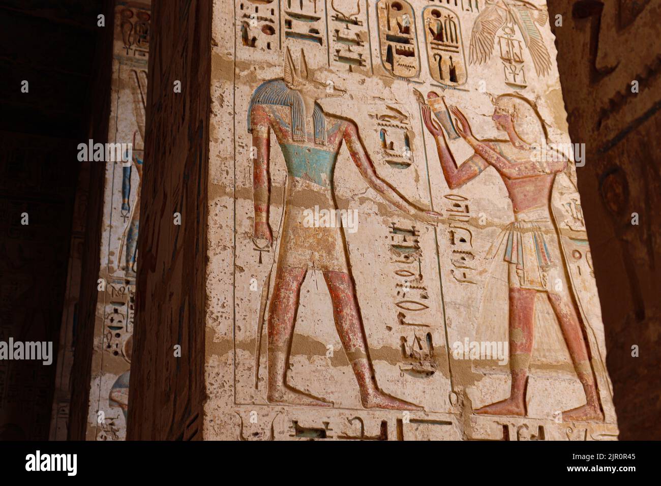 well-preserved colorful reliefs at the mortuary temple of Ramses III (Medinet Habu) at the west bank of river Nile in Luxor Stock Photo