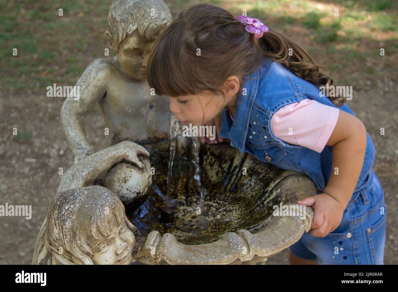 Image of an adorable little girl drinking water from a decorated