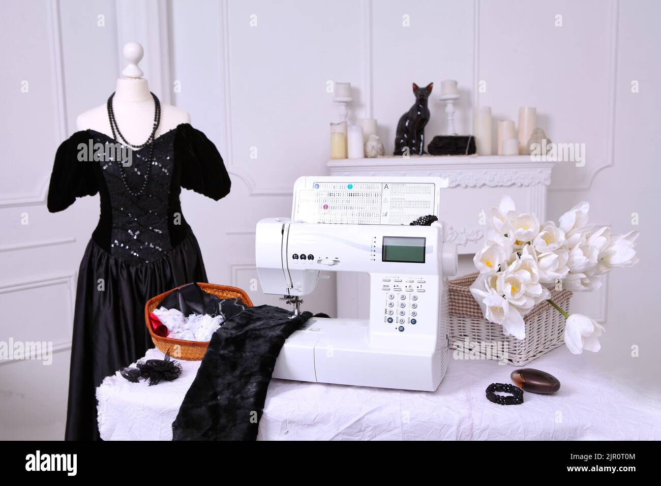 Composition from a sewing machine. Mannequin, flowers on a retro table
