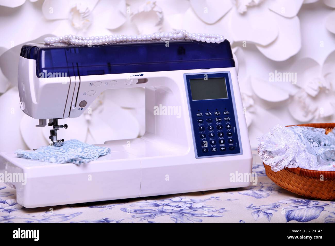 Composition from a sewing machine. Mannequin, flowers on a retro table