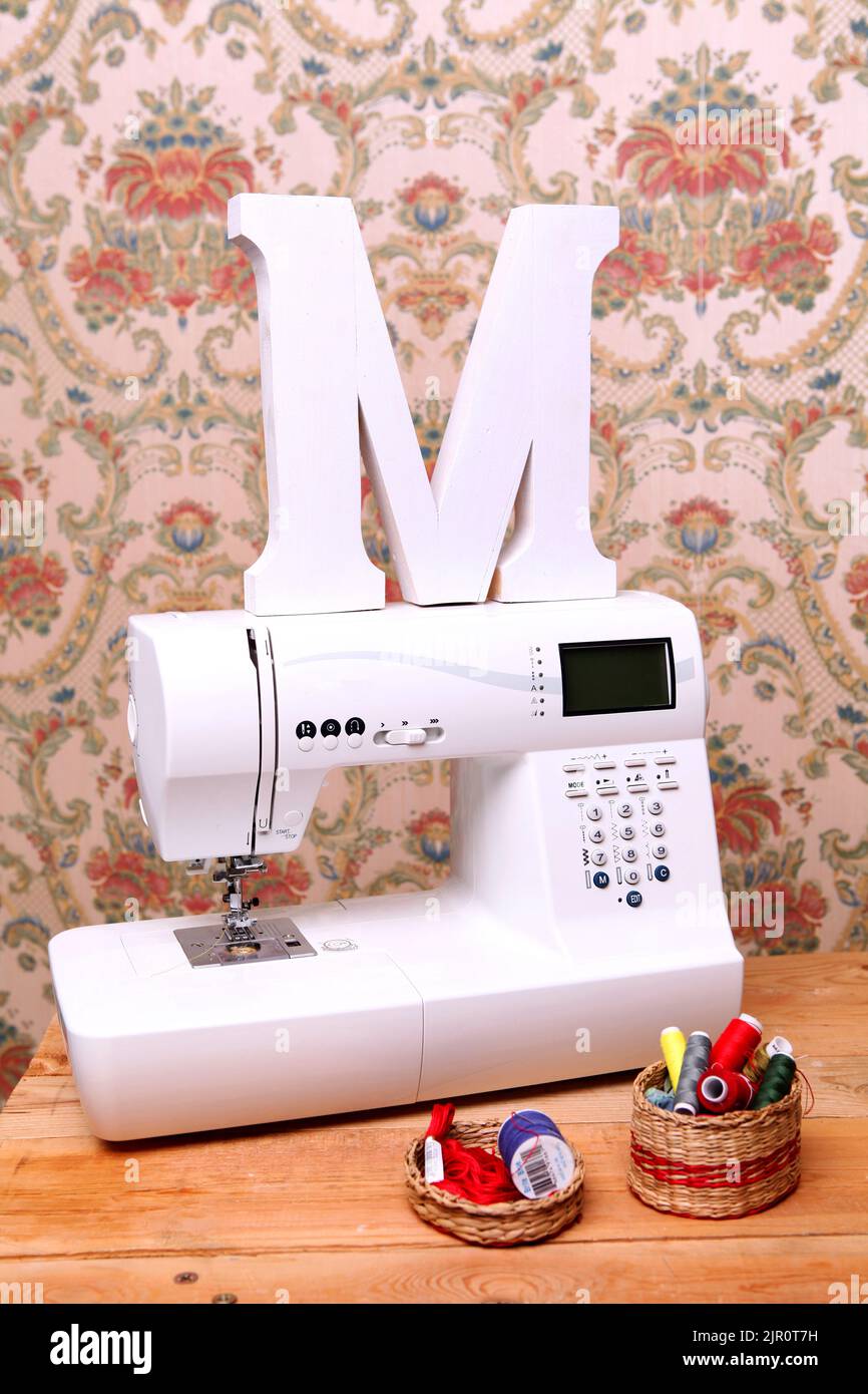 Composition from a sewing machine. Mannequin, flowers on a retro table