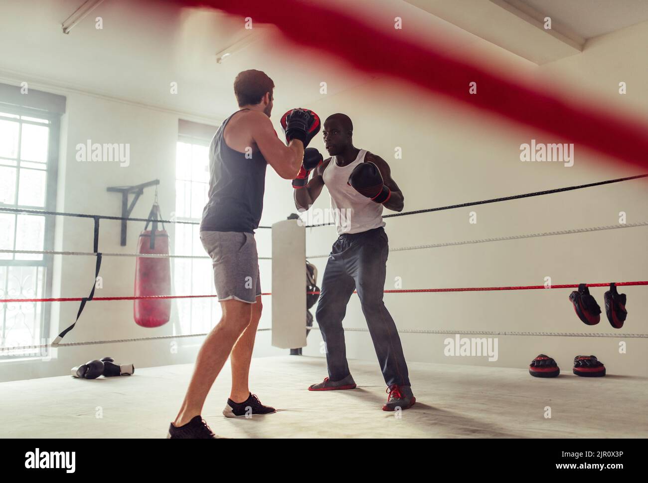 Physical trainer coaching a boxing athlete in a gym. Boxing coaching