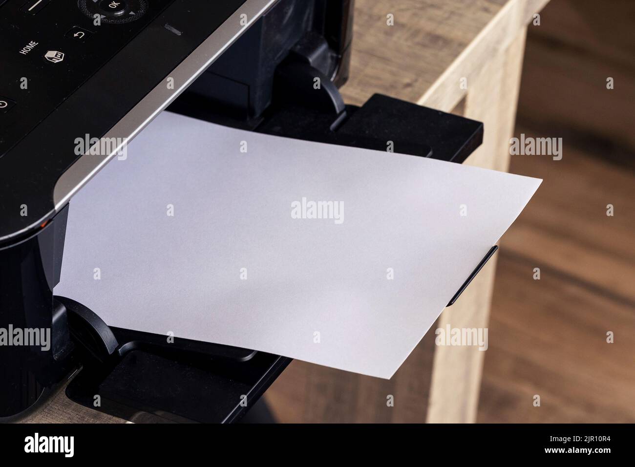 A portrait of a printer with an empty white page in its printed output