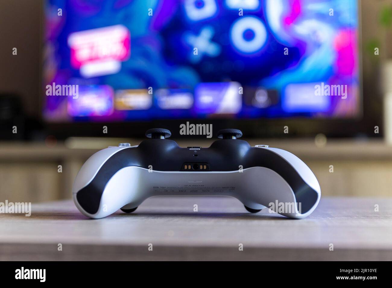 man with a controller standing in front of a PC console TV screen with a  steam controller playing popular free to play game Roblox Stock Photo -  Alamy