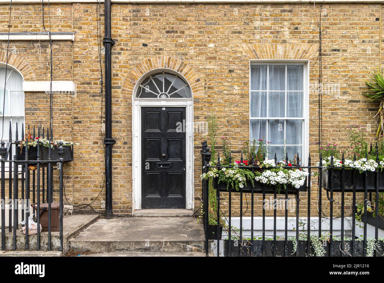 A black front door with a fan light above it at the entrance to a mews house on Warren Street in Fitzrovia , London W1 Stock Photo