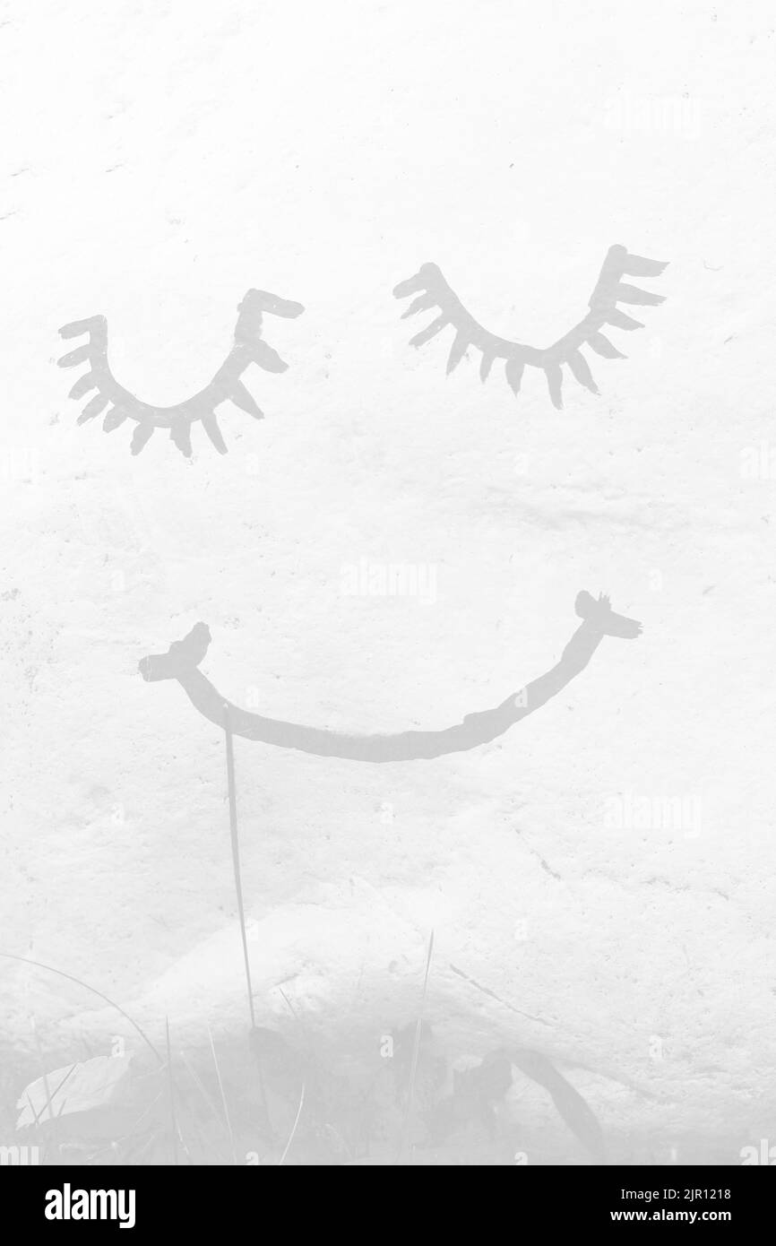 Happy smiley face painted on a garden rock as an inspirational message