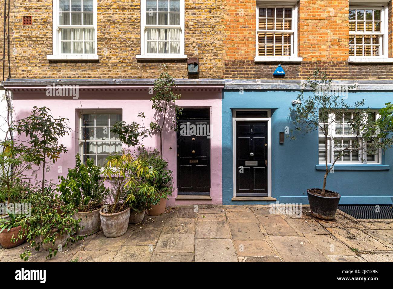 Brightly painted front doors on a row of pastel coloured houses