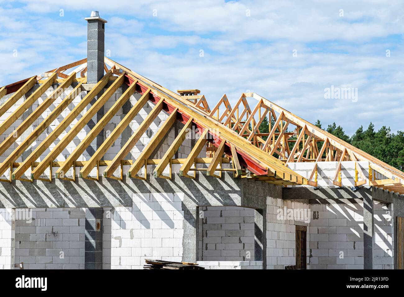 Roof trusses connected to the roof truss, not covered with a roof, with a steel I-beam instead of a corner rafter. Stock Photo