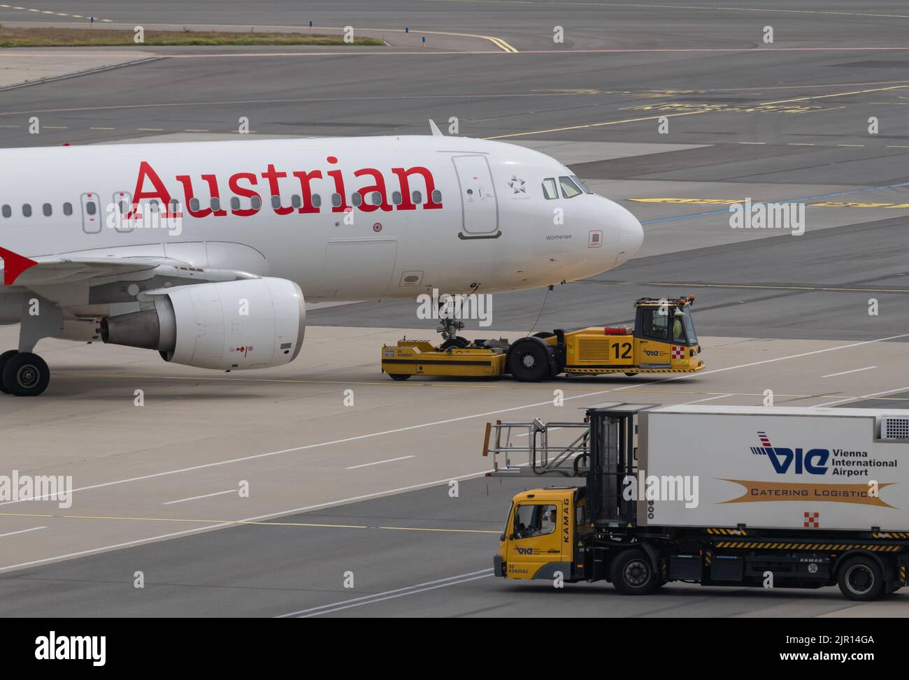 Airport Ground Staff With Pushback Tractor Towing Airplane To Runway For Departure Stock Photo