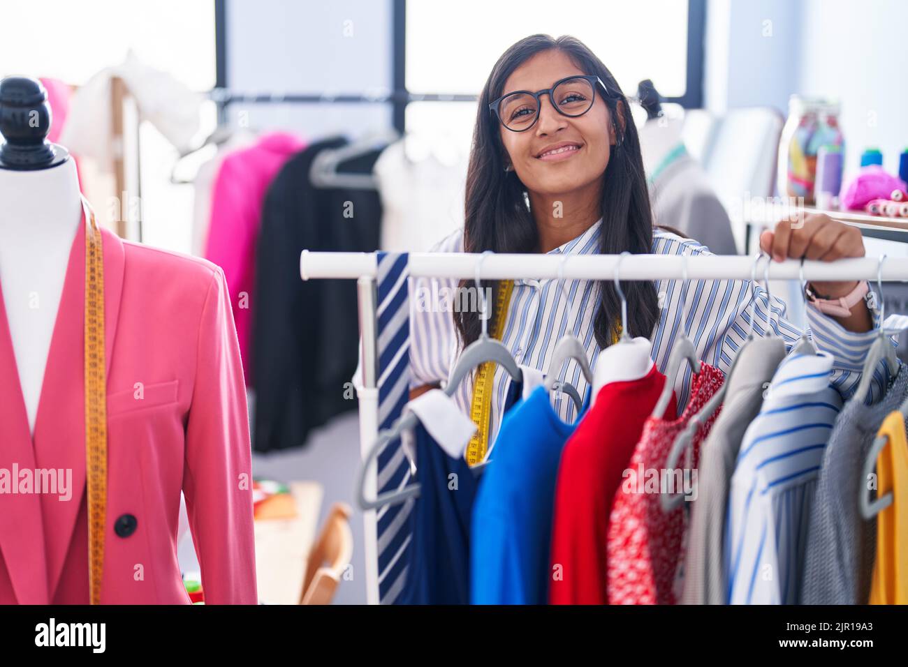 Hispanic Rack Young beautiful hispanic woman tailor smiling confident leaning on ...
