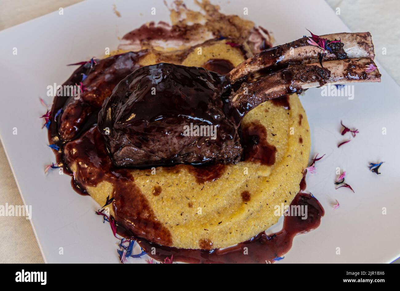 Venison Ribs with polenta and  beetroot sauce:traditional dish of northern Italy - South Tyrol Stock Photo