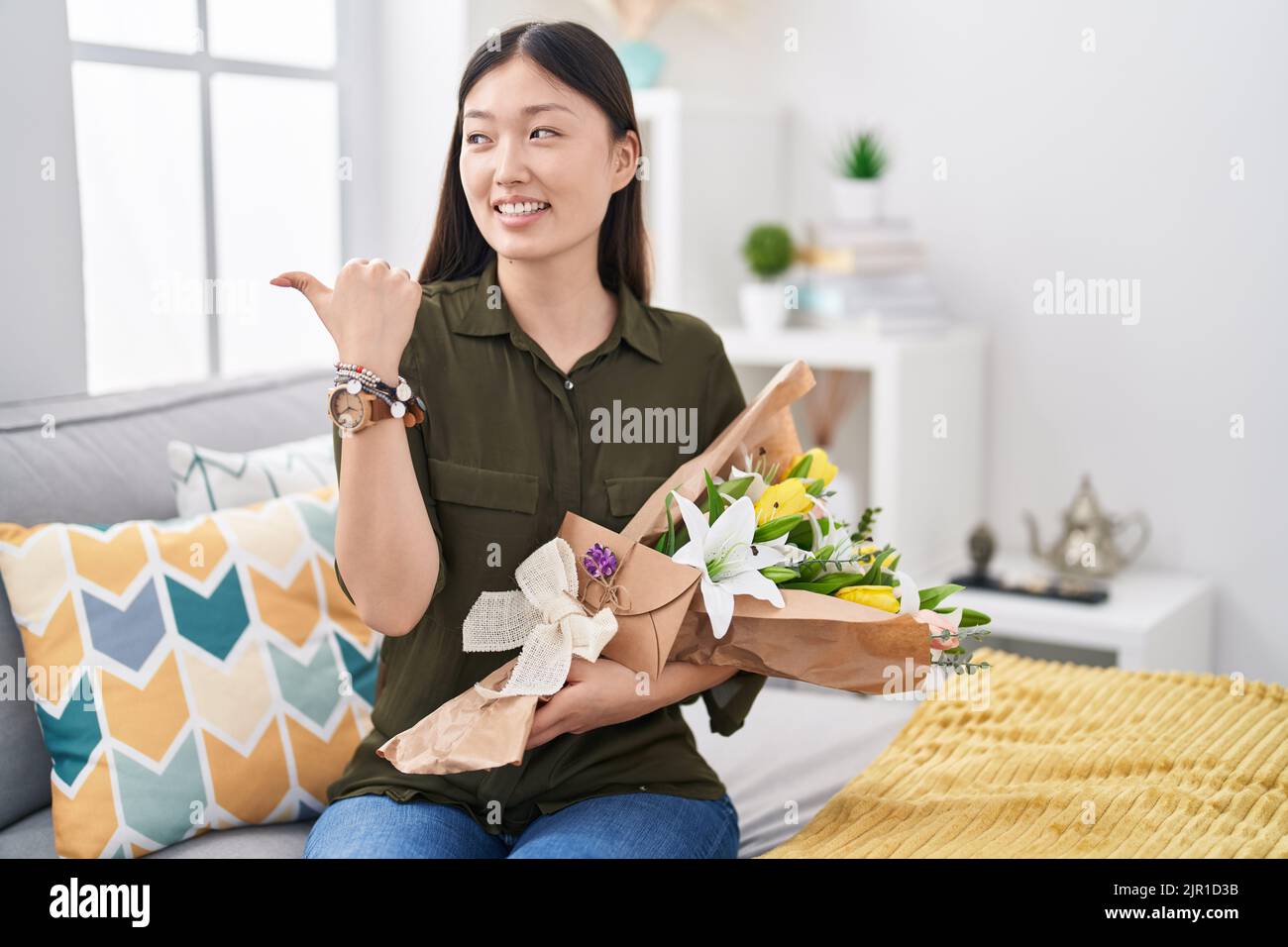 Chinese young woman holding bouquet of white flowers smiling with happy ...