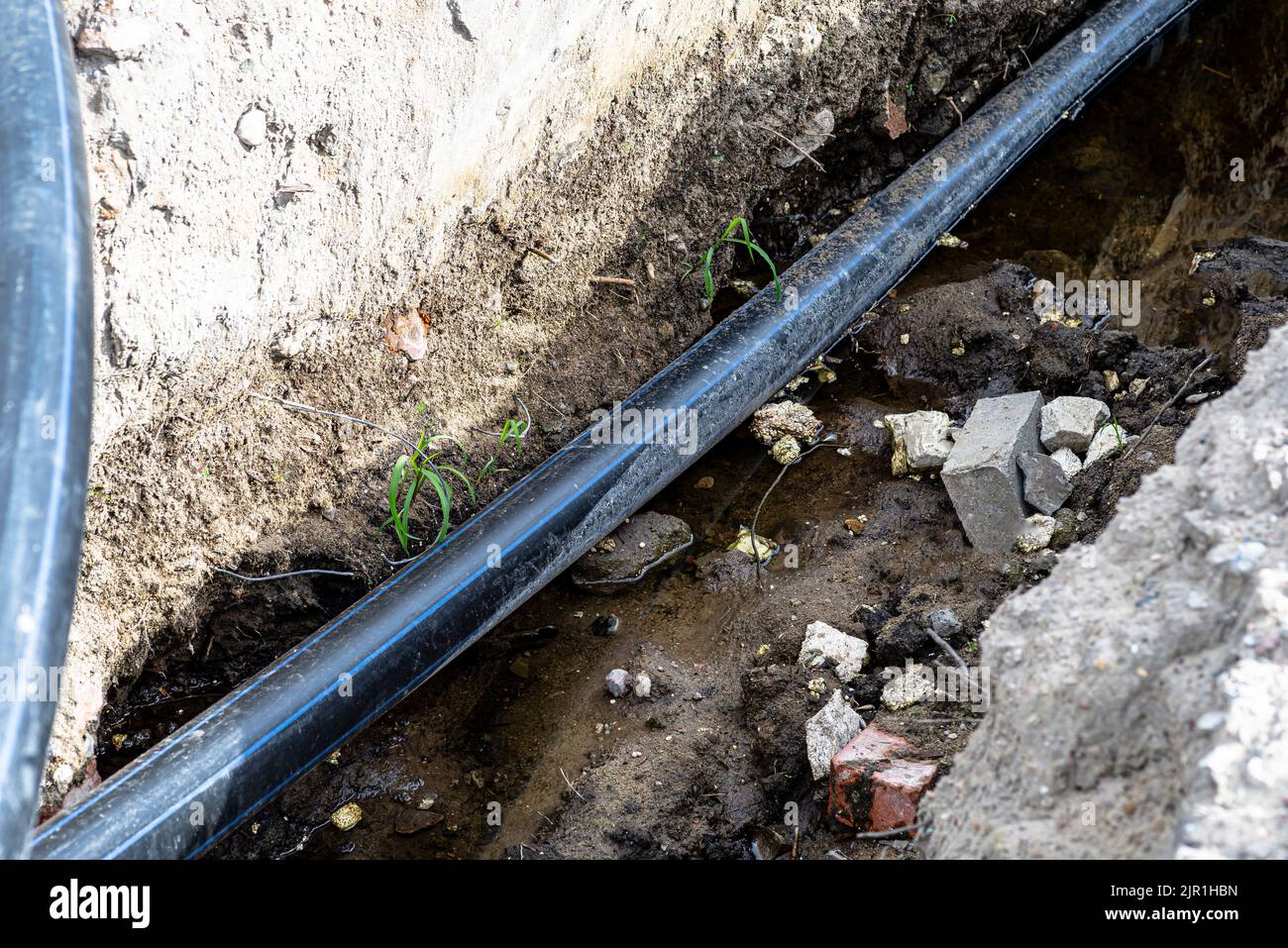 Plastic water pipe lying in a ditch with high groundwater, water