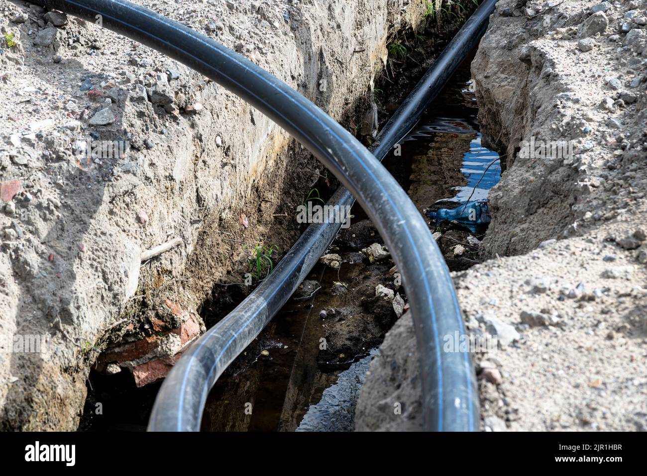 Plastic water pipe lying in a ditch with high groundwater, water