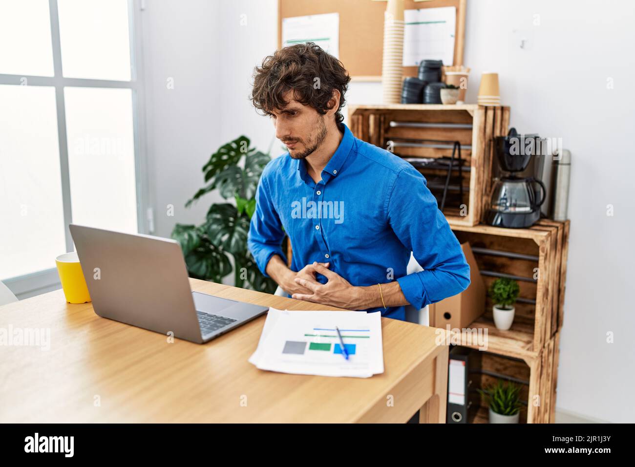 Hispanic Man Using Computer Young hispanic man with beard working at the office using computer ...