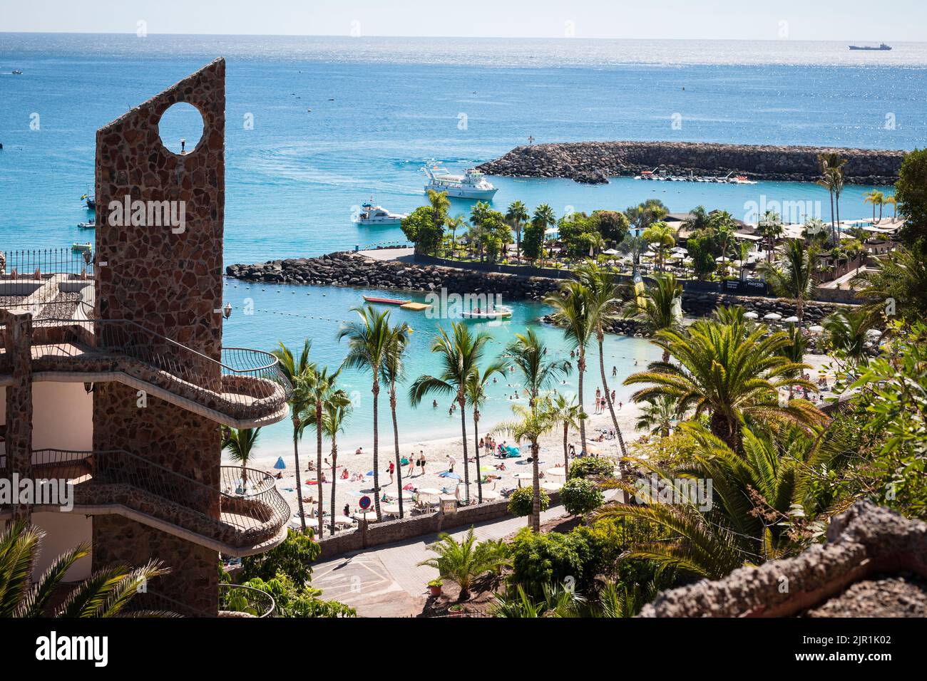 View of beach in Gran Canaria (Canary Islands) with palm trees, white