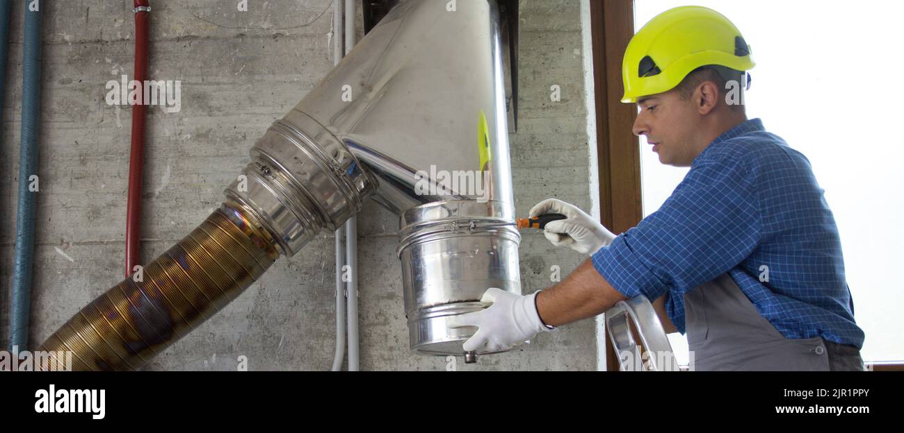 Image of a hardhatted handyman plumber on a ladder repairing and
