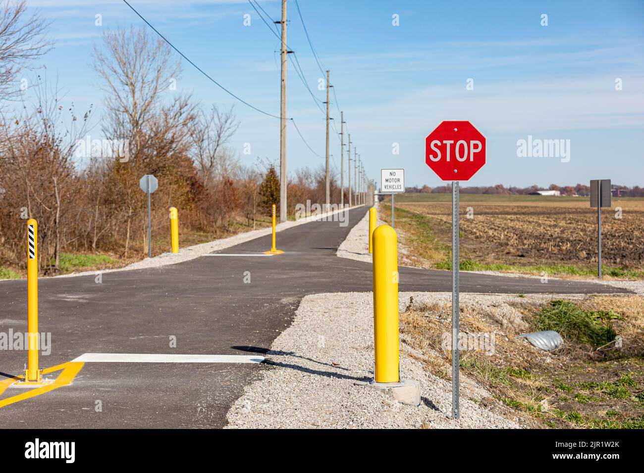 Multipurpose or multiuse bike trail with traffic barriers and stop sign. Rail trail, outdoor recreation and bike path safety concept. Stock Photo
